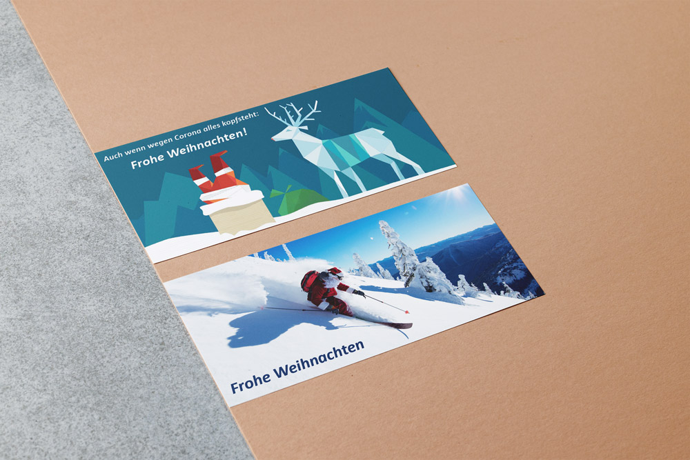 Weihnachtskarten für das Architekturbüro Eisenbraun und Eisenbraun Immobilien mit dem Thema "Weihnachtsmann im Schnee". Die Karten zeigen einen Weihnachtsmann kopfüber im Schornstein und einen Weihnachtsmann beim Skifahren im Tiefschnee.